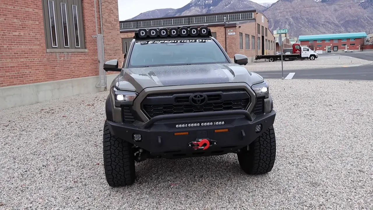 front view of Expedition One Tacoma with steel bumper, integrated lights, red ComeUp winch hook and roof lightbar