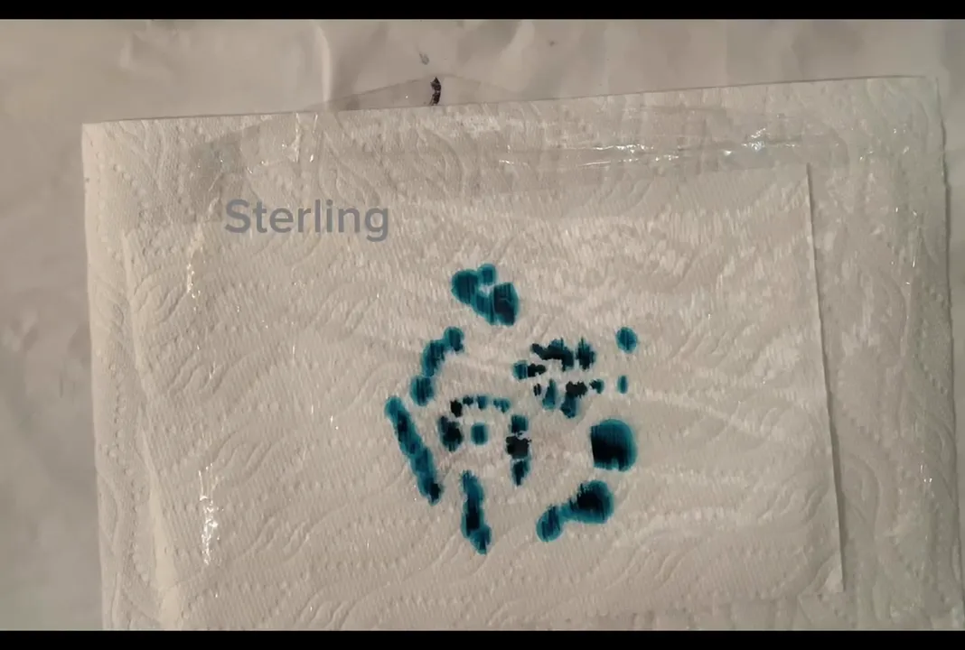Teal and blue alcohol ink drops on plastic wrap with on-screen label 'Sterling', ready for plastic-wrap transfer