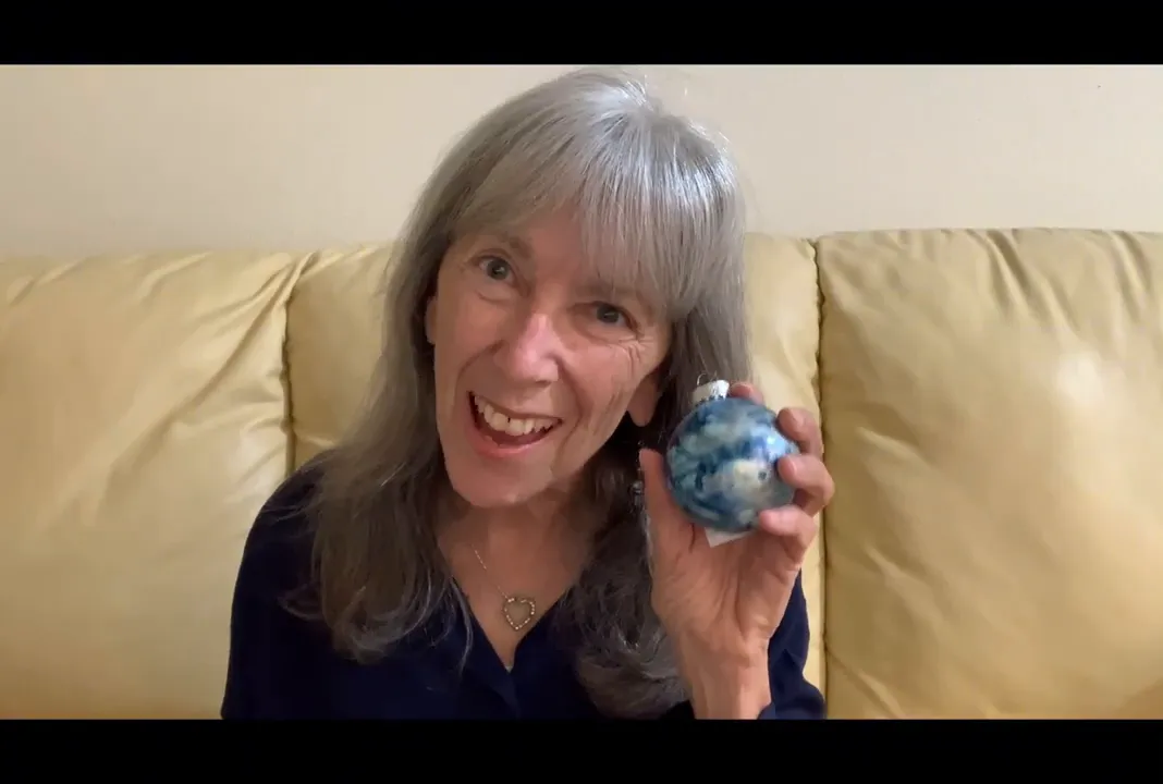 Hand holding a blue marbled alcohol-ink glass ornament