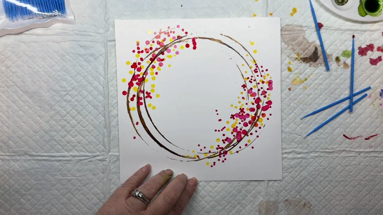 Adding clusters of orange and purple alcohol ink dots to the wreath