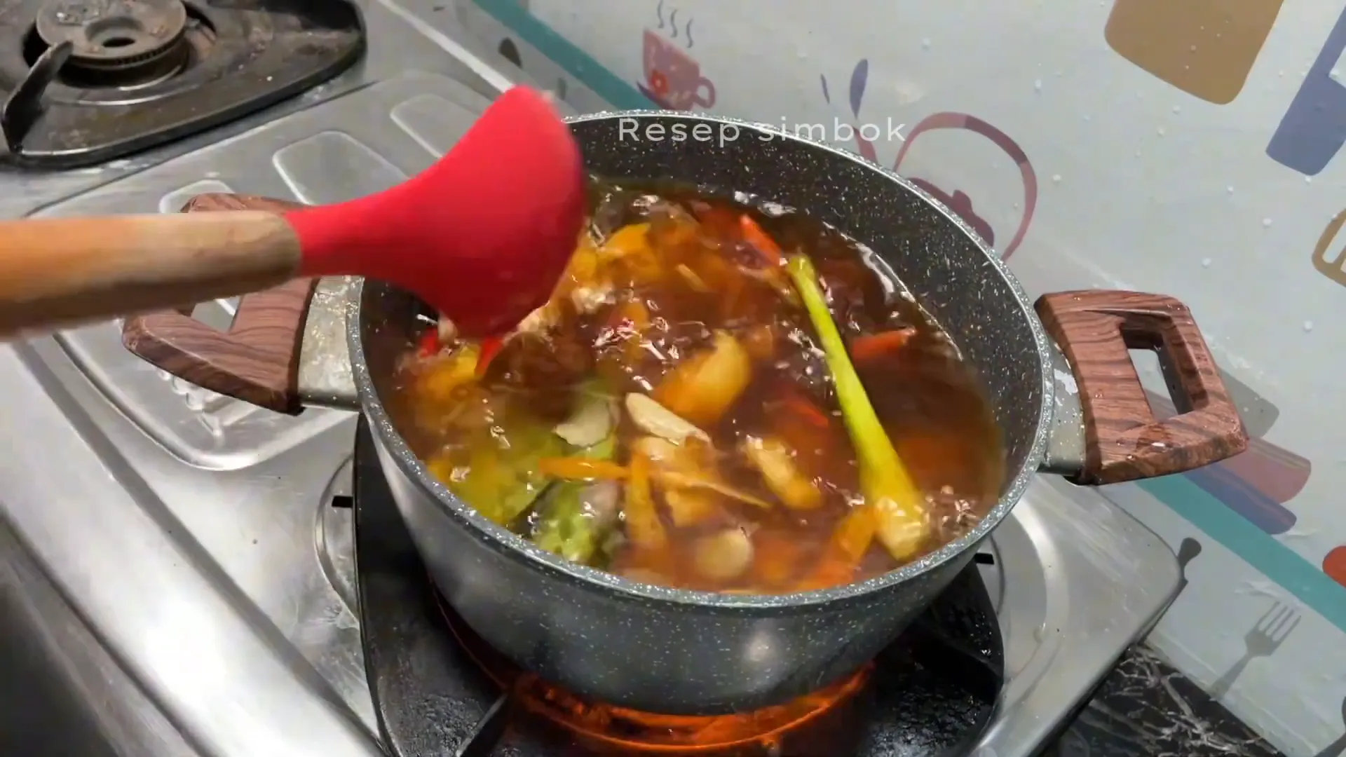 Ayam kuah kecap sedang dimasak dengan bumbu dan sayuran
