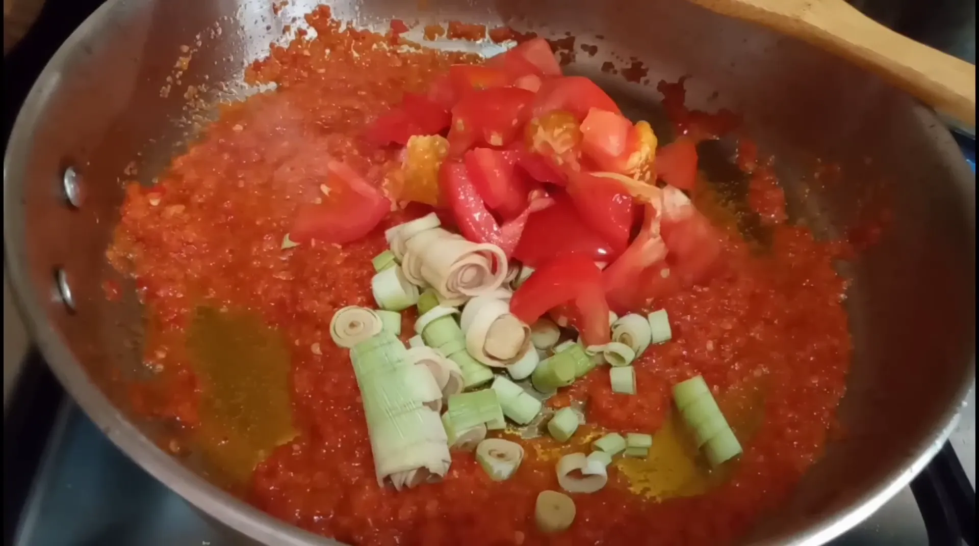 Tumis bumbu halus bersama sereh, tomat, dan daun bawang sebelum memasukkan cumi