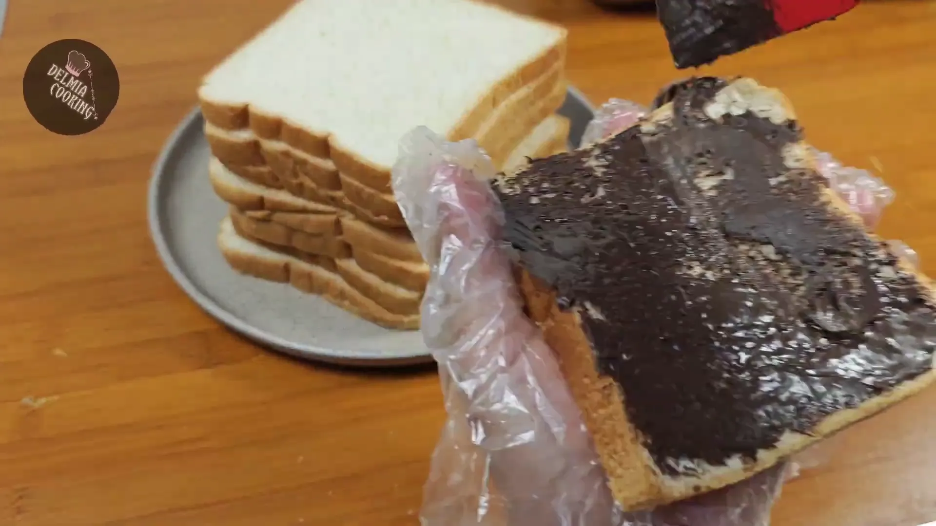 Proses melapisi roti dengan selai coklat dan meses