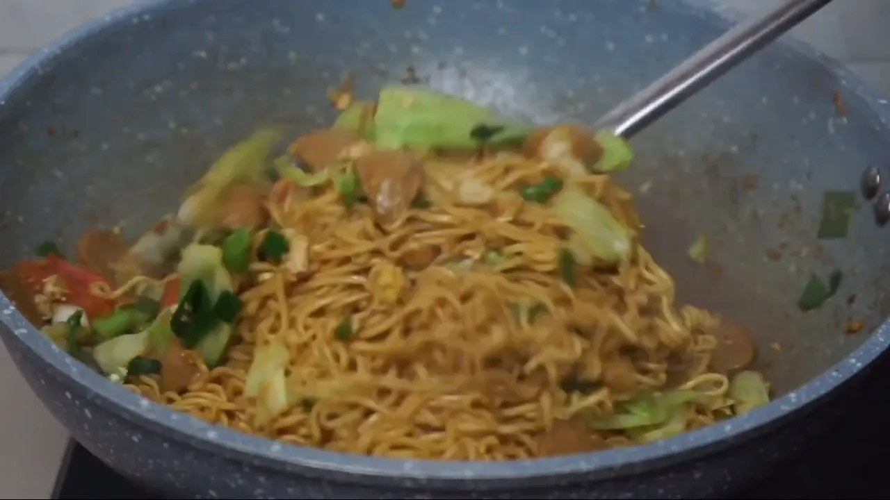 Mie goreng siap disajikan dengan kerupuk dan acar