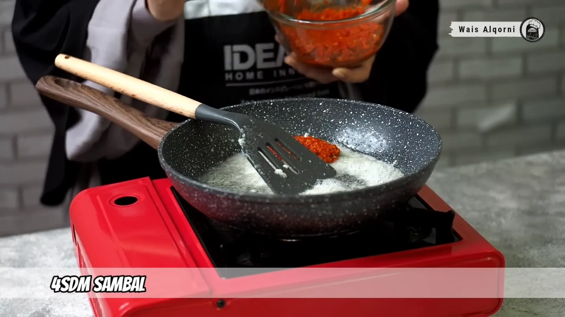 Menumis bawang putih dan saus cabai untuk membuat saus pedas