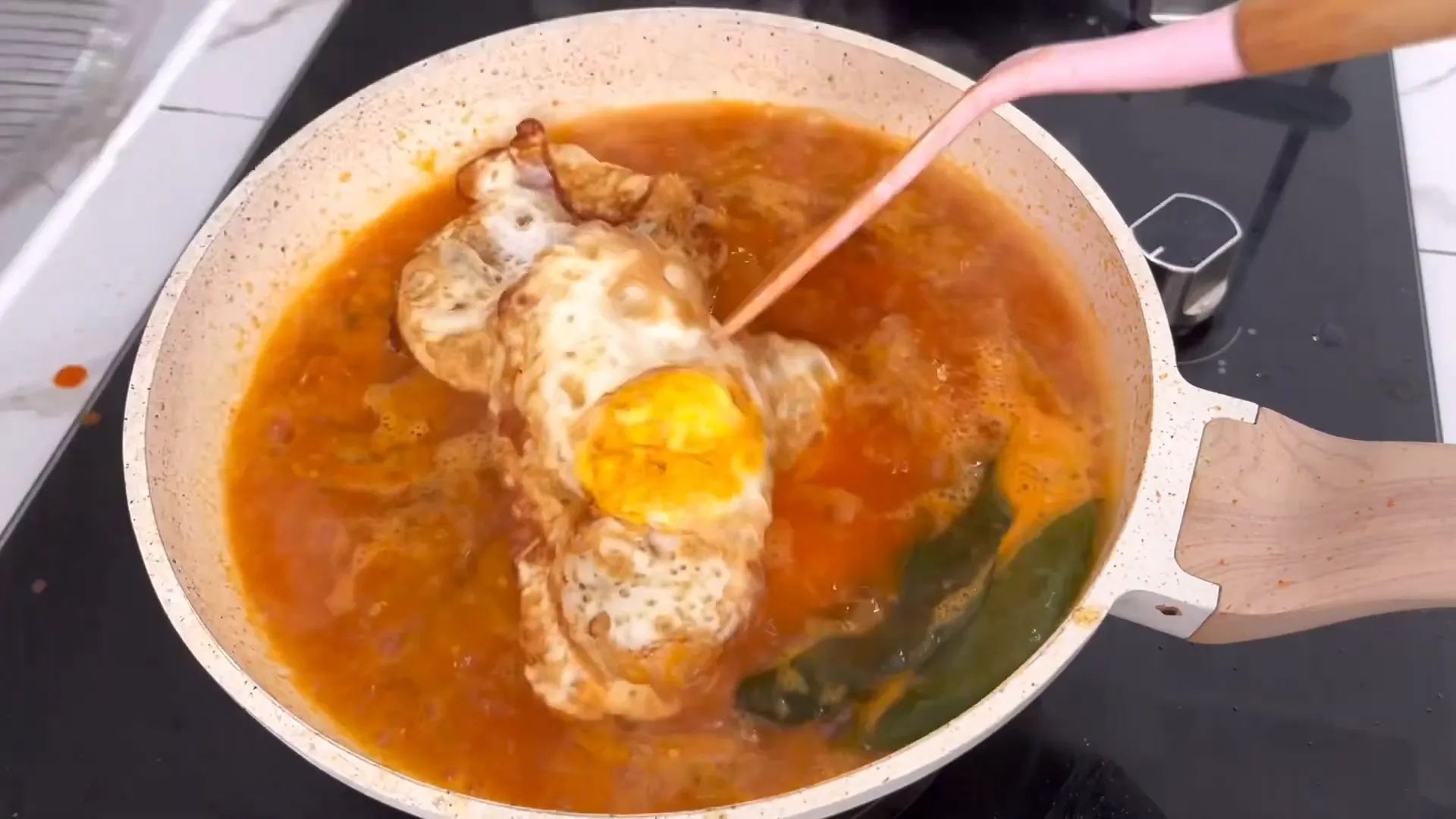 Memasukkan telur ceplok ke dalam kuah bumbu