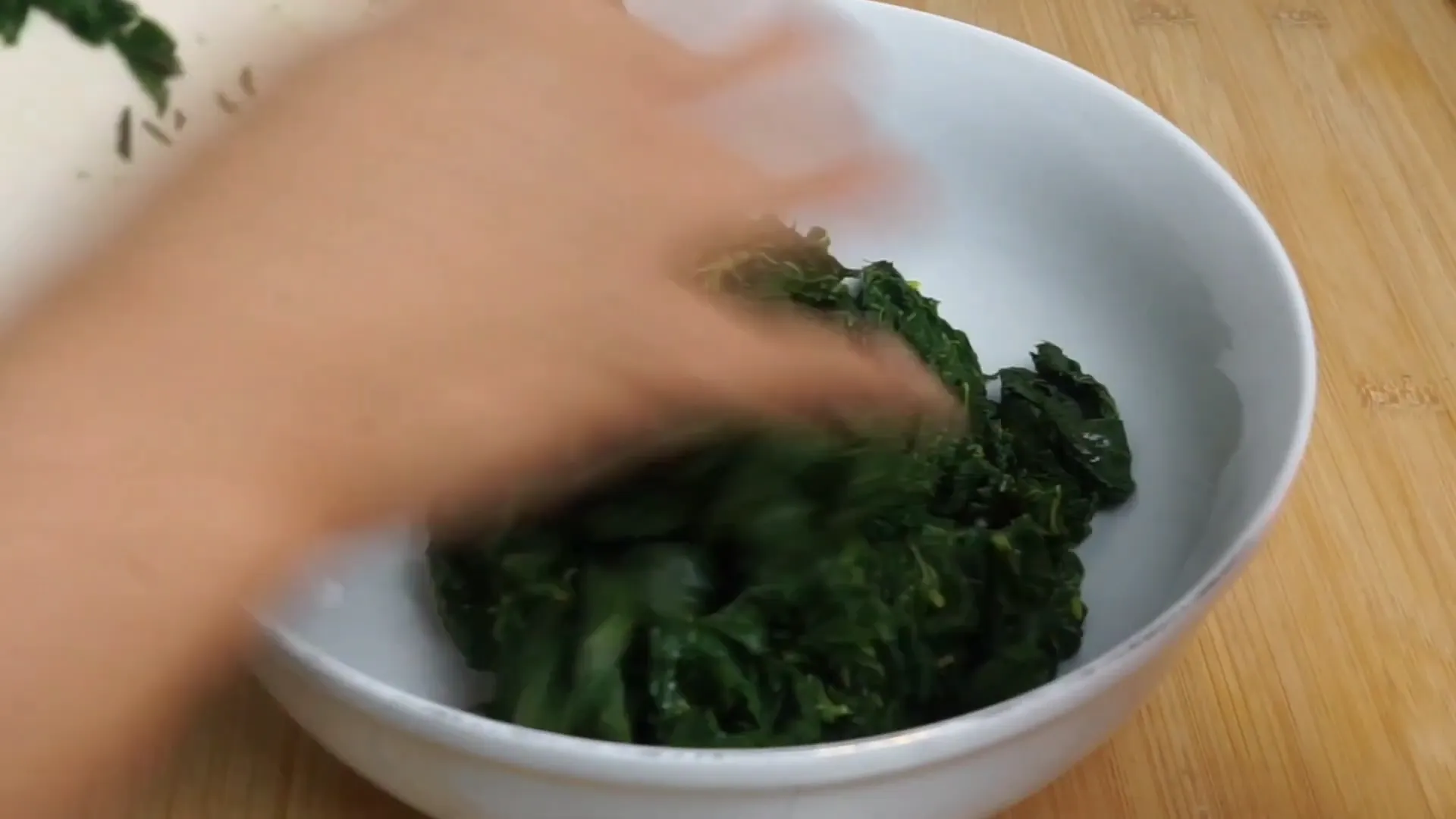 Daun singkong dicelupkan ke air dingin agar tetap hijau