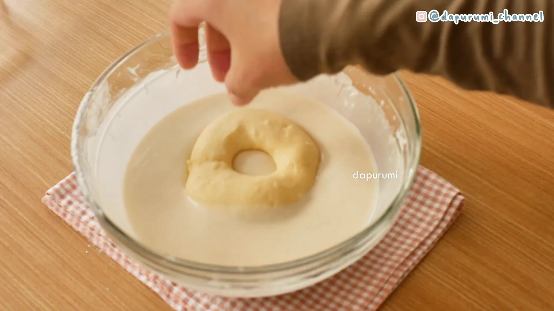 Donat yang sudah mengembang dicelupkan ke adonan pencelup sebelum digoreng