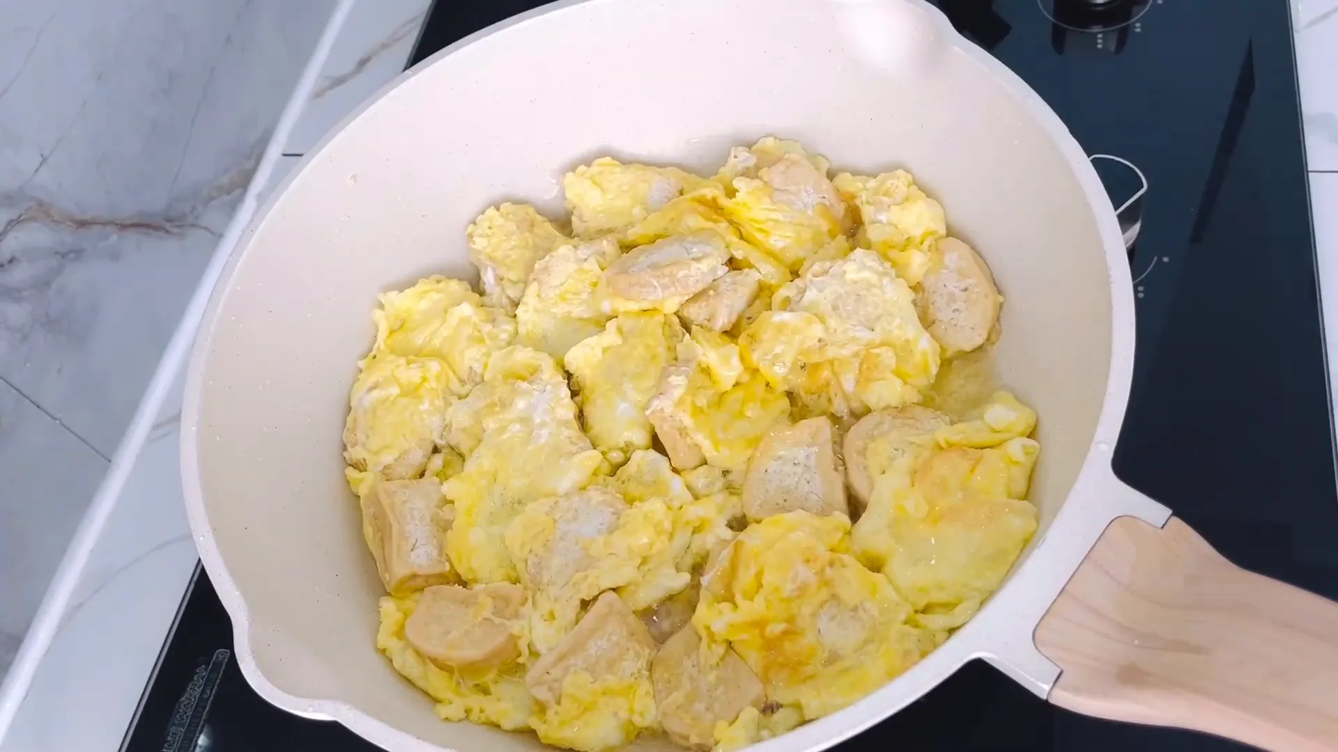 Tahu dilapisi telur berbumbu sedang digoreng dengan api kecil