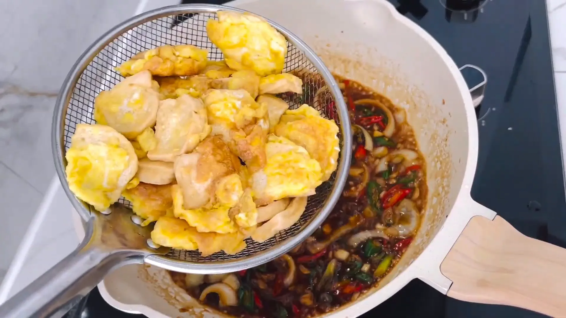 Tahu dan telur dicampur dengan saus teriyaki di atas penggorengan