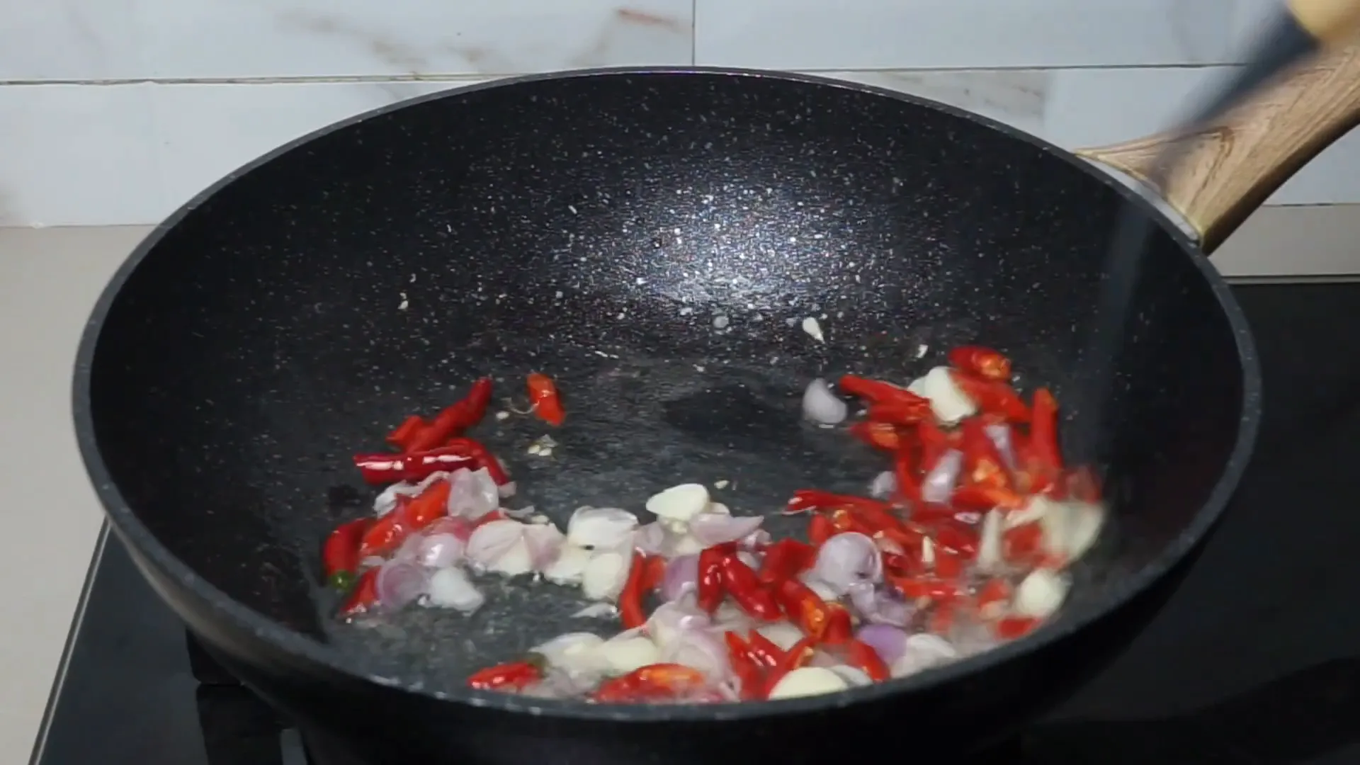 Proses menumis bawang merah, bawang putih, dan cabai hingga harum