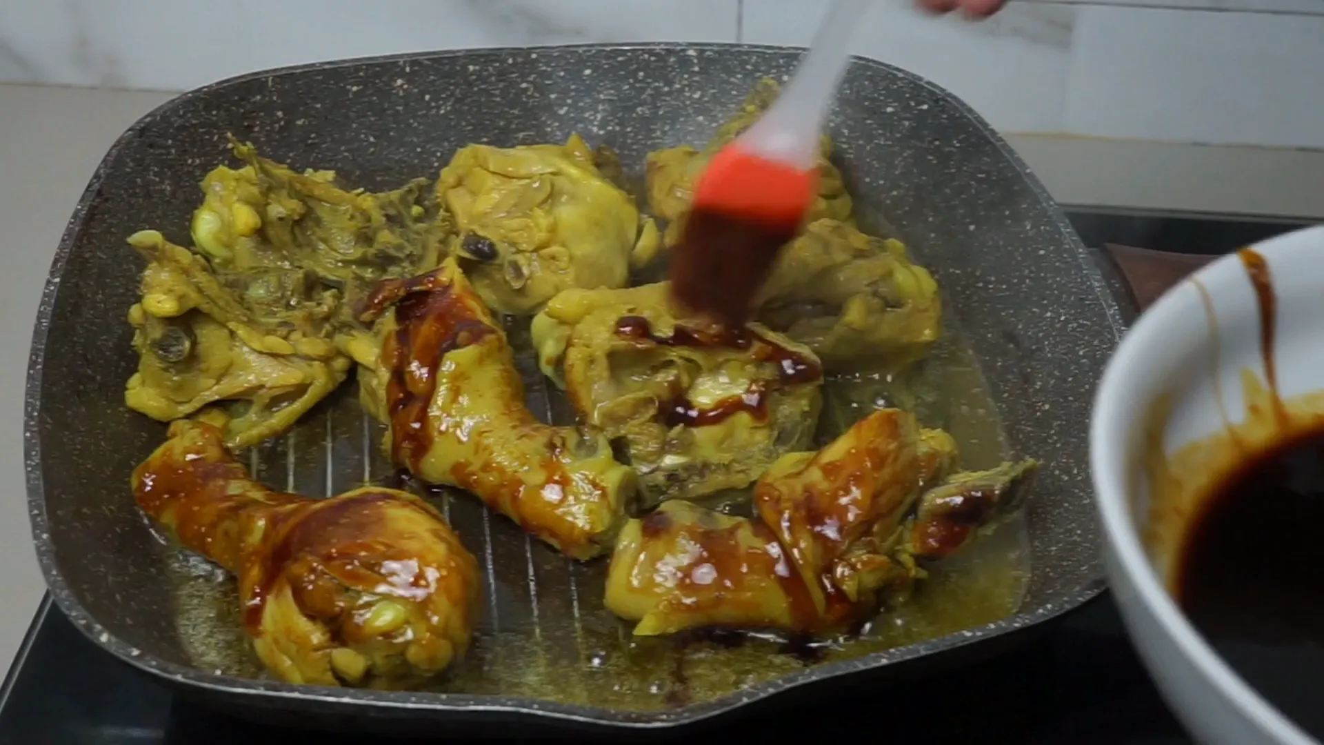 Memanggang ayam sambil diolesi bumbu