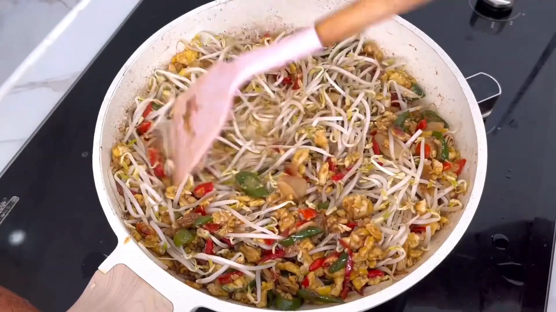 Mencampur toge dengan telur dan bumbu di wajan