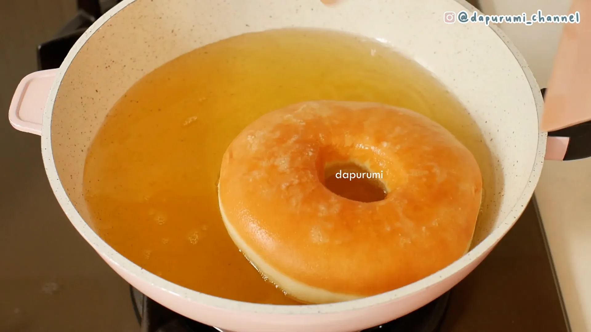 Menggoreng donat jumbo dengan hati-hati untuk mendapatkan kematangan merata