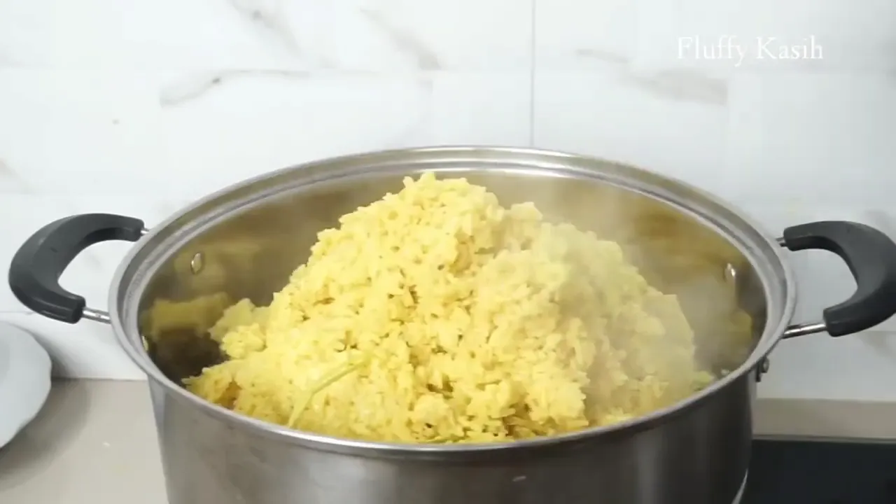 Nasi kuning sedang dikukus dalam dandang
