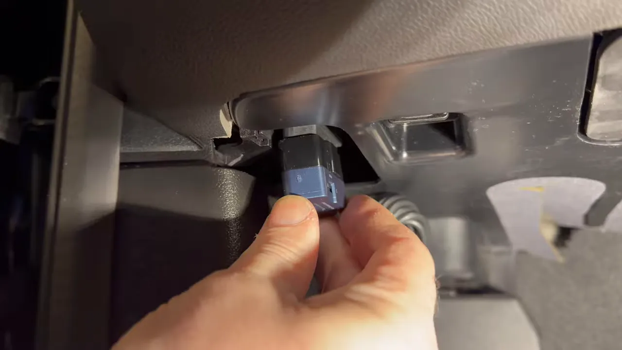 Hand plugging in a dash cam power adapter connection