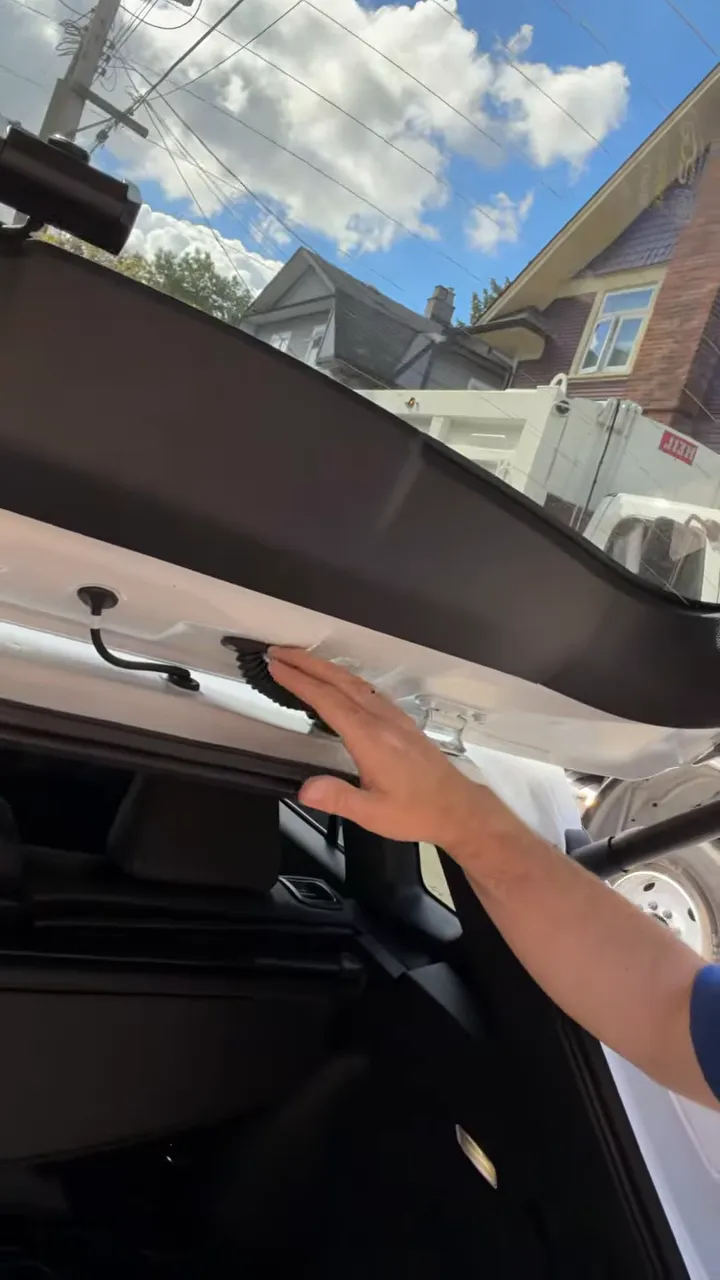 Rear hatch area showing factory grommet and hidden wire routing path for the dash camera