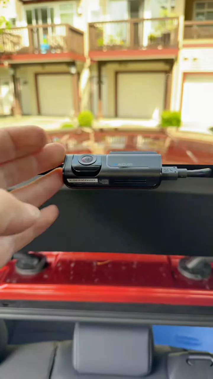 Rear dash camera mounted at the back window with cable connected on the right side