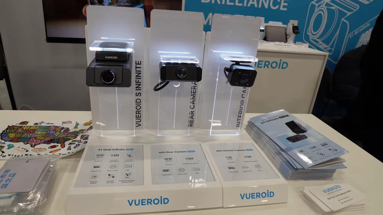 Front-on shot of Vueroid S1 demo showing three camera modules on illuminated stands with spec cards and brochures.