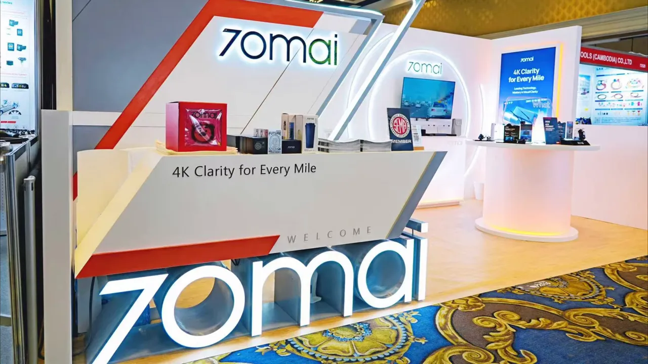 70mai tradeshow booth counter with illuminated 70mai logo and '4K Clarity for Every Mile' signage with product boxes on the counter.
