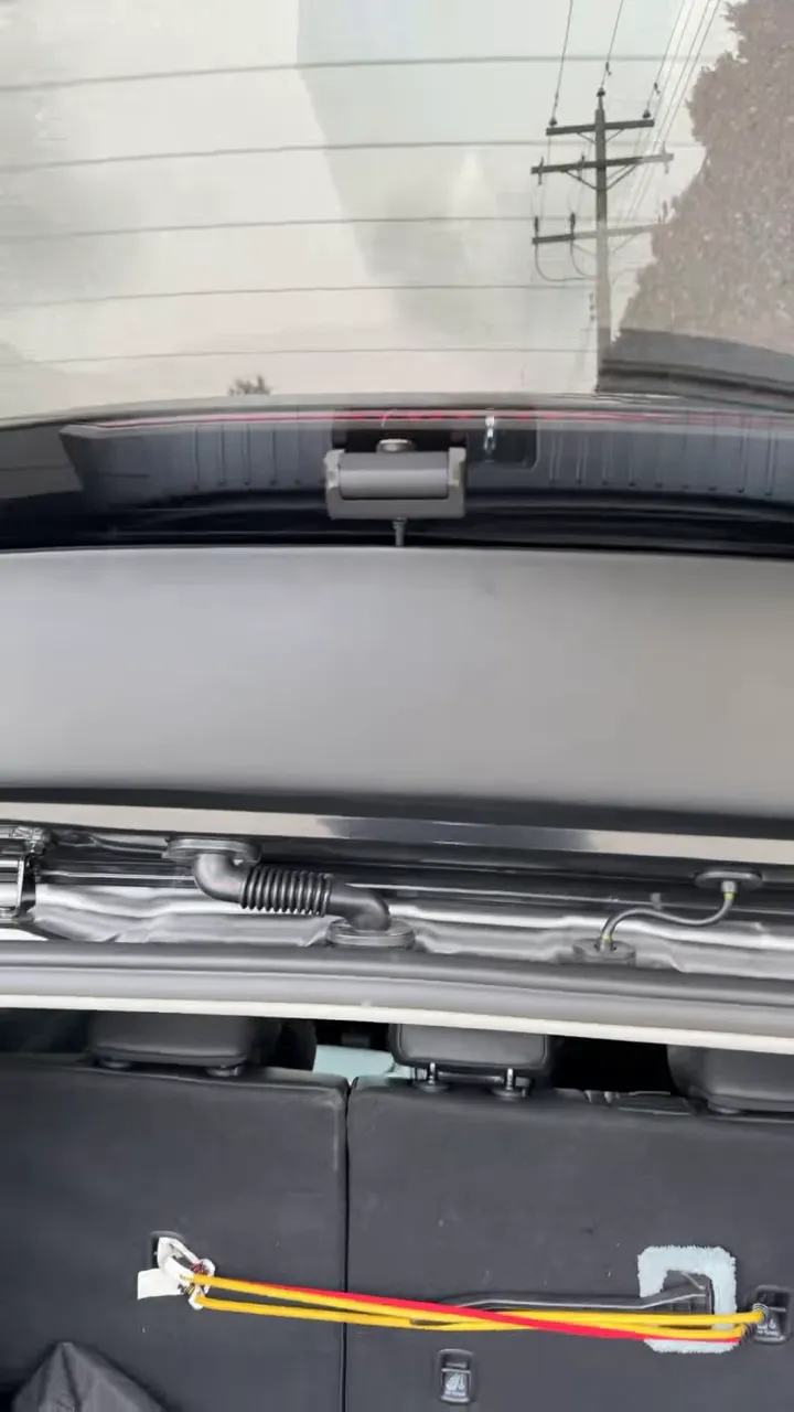 Rear window mounting area showing dash cam bracket and wiring setup