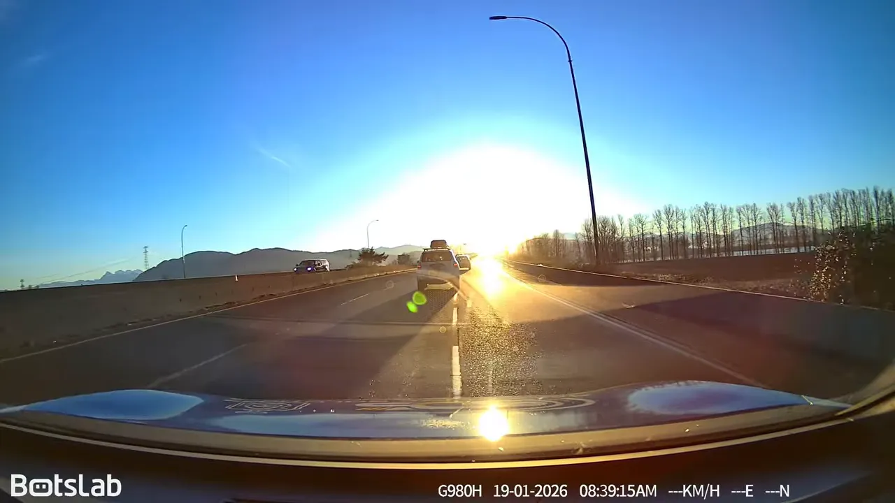 Forward road view with heavy sun glare washing out the lane ahead