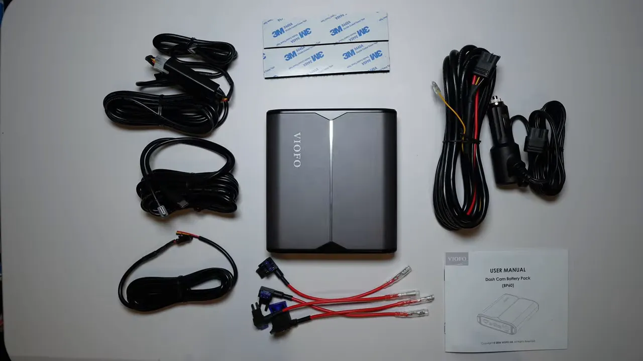 VIOFO BP60 battery pack surrounded by cables, mounting strips, fuse taps and a manual on a white table