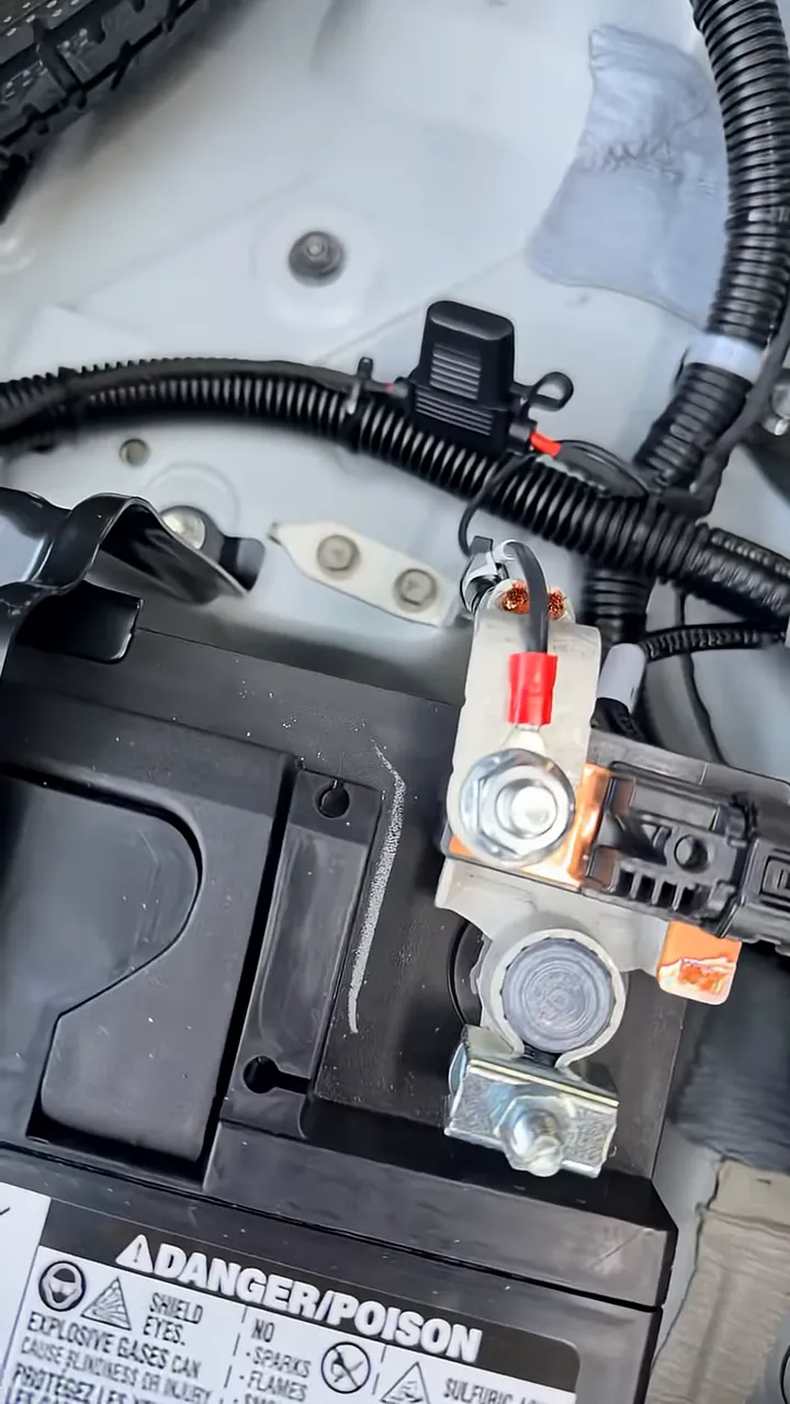 Close-up of dash cam battery pack power and ground connection hardware in the Lexus RX350h hatch area