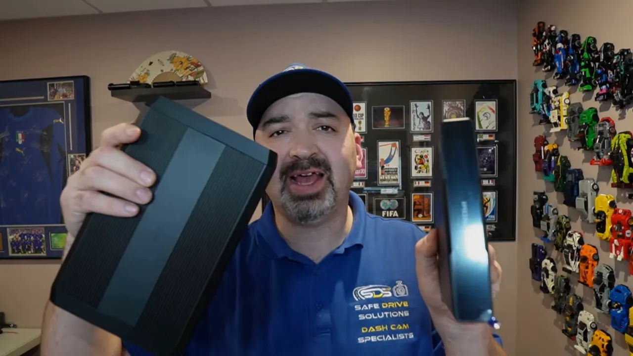 Presenter holding two external battery packs side-by-side to compare size and design