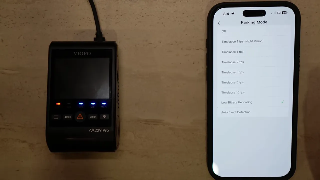 Phone showing VIOFO app 'Parking Mode' options with 'Low Bitrate Recording' checked and the A229 Pro dashcam beside it.