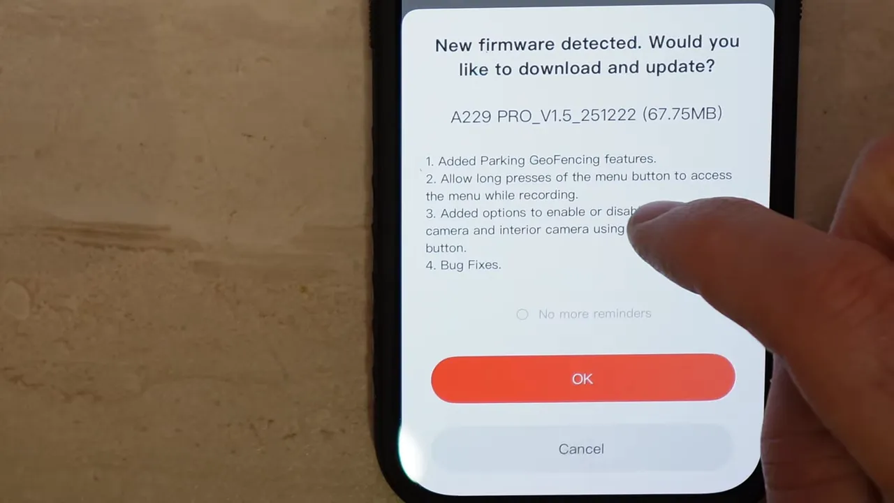 Phone screen showing 'New firmware detected' dialog with OK button and a finger about to tap