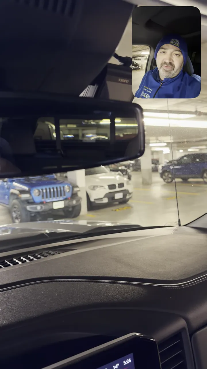 Dash camera mounted above rearview mirror inside GMC Sierra showing unobstructed forward view