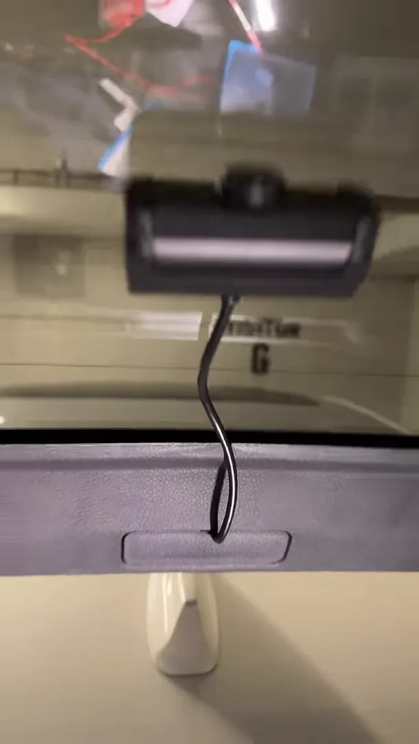 Close-up of rear dashcam and cable exiting through hatch trim