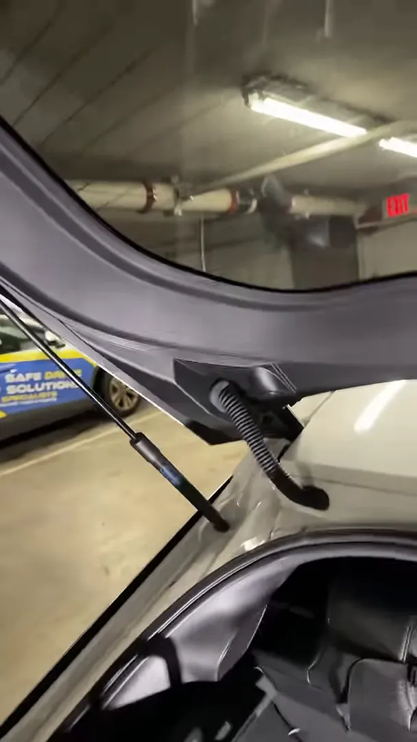 Rear hatch interior showing trim seam, gas strut and flexible wiring boot where the camera cable can catch.