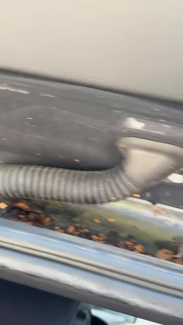 factory grommet and corrugated conduit with dash cam wiring routed through the hatch jamb of a Mini Cooper Countryman