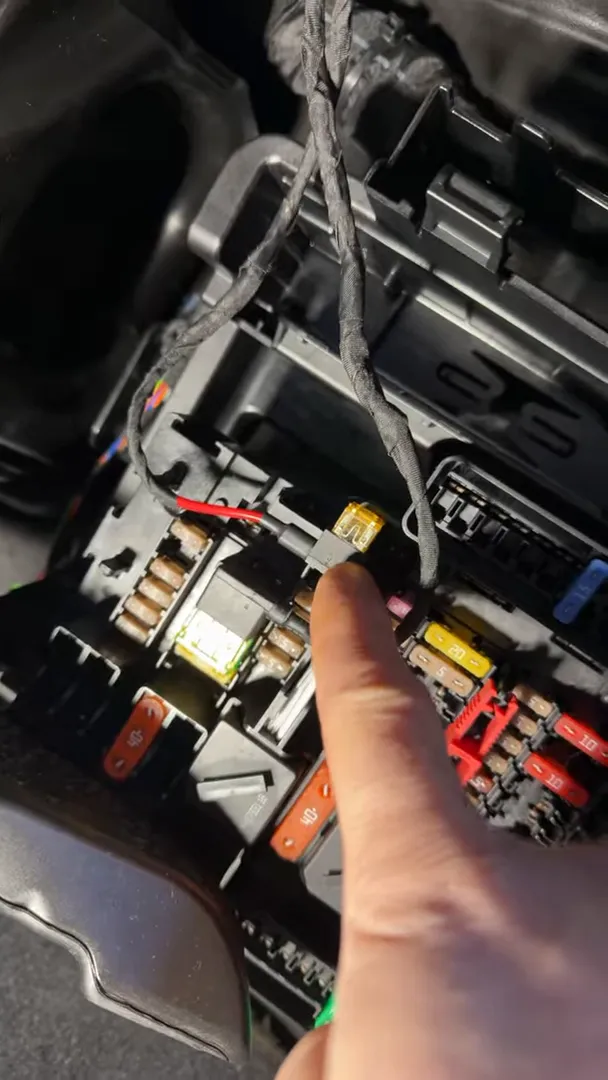 Finger indicating a fuse tap used for dash cam power in the Countryman fuse box
