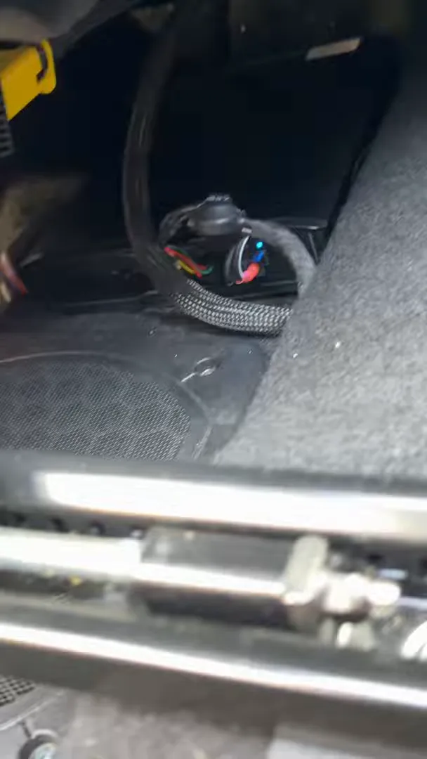 Close-up of Thinkware Ivolt Extra under passenger seat showing braided cable and ground connector