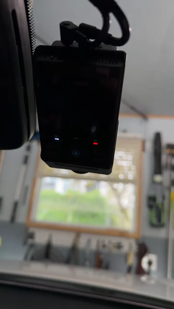 Aftermarket dash camera mounted beside the factory windshield camera with illuminated status lights