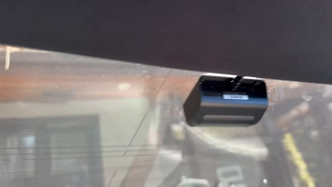Compact front dash camera mounted high on the Nissan GTR windshield