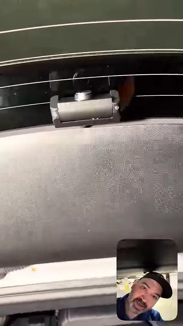 Close-up of a rear dash camera mounted to the Equinox rear window with headliner and mount clearly visible