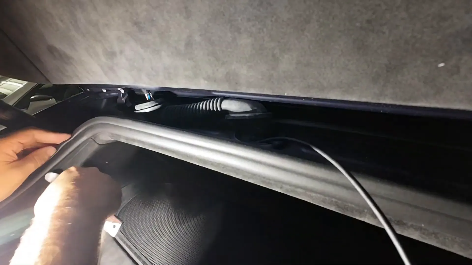 Fishing the rear camera cable into the rubber boot that connects the hatch to the car body
