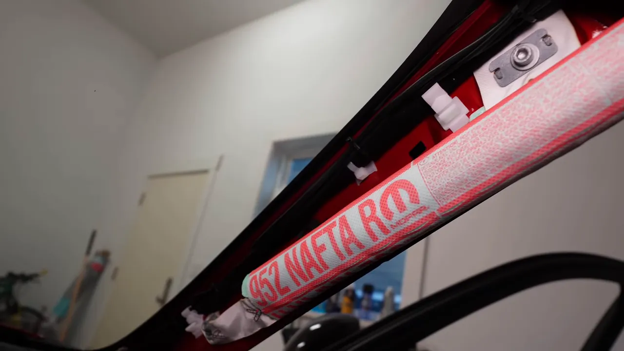 A-pillar with side airbag strap and clips showing routing path for dash cam wiring in Alfa Romeo Giulia