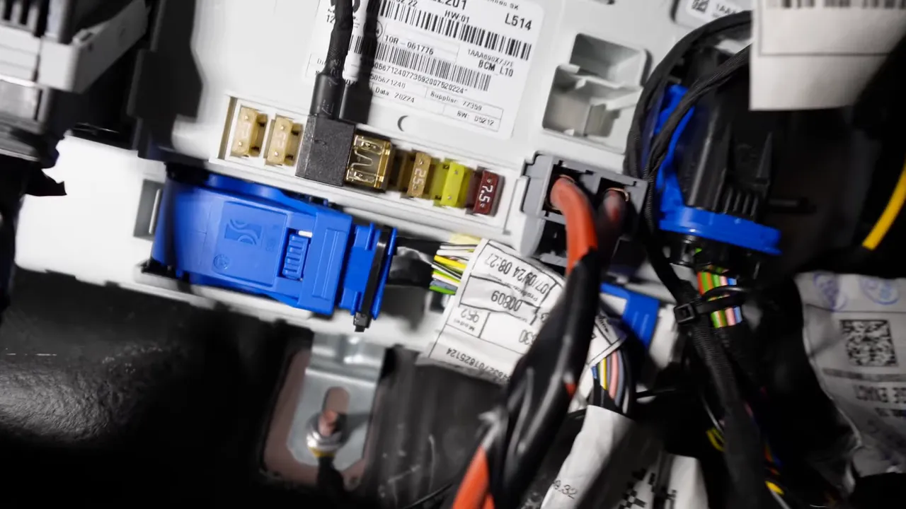 Close-up of Alfa Romeo Giulia fuse panel with nearby chassis bolt used for ground connection