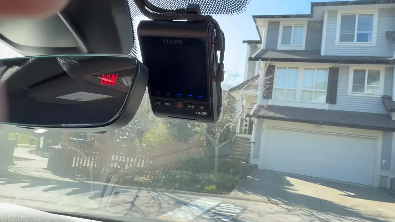 Viofo A329 dashcam powered on and mounted at the windshield with status LEDs visible