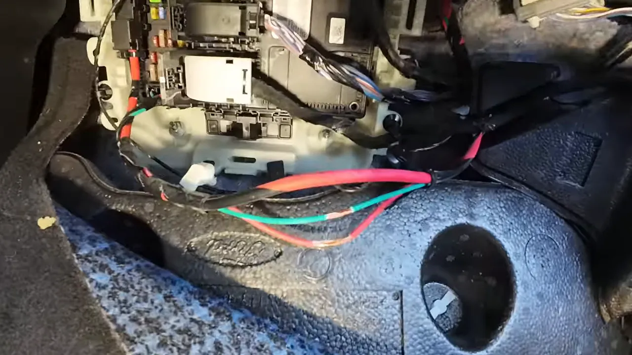 Red and green vehicle wires exposed near the Ford Maverick fuse box