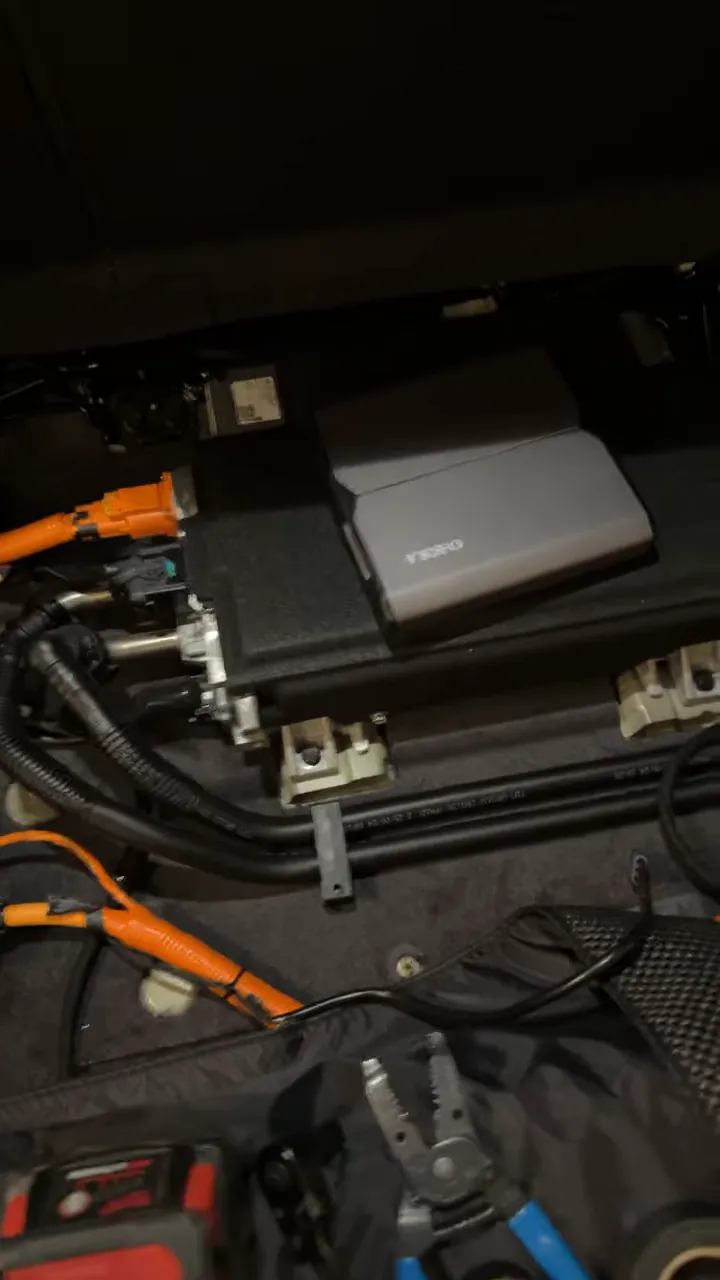 VOFO battery pack mounted in the 2026 Kia EV9 rear storage area with orange wiring and tools visible.