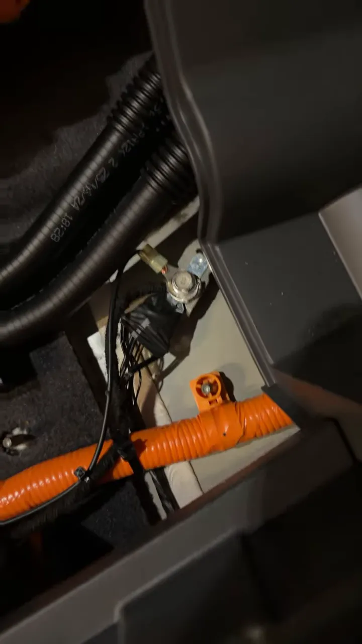 factory ground bolt with ring terminal and wiring in the rear cargo of a Kia EV9
