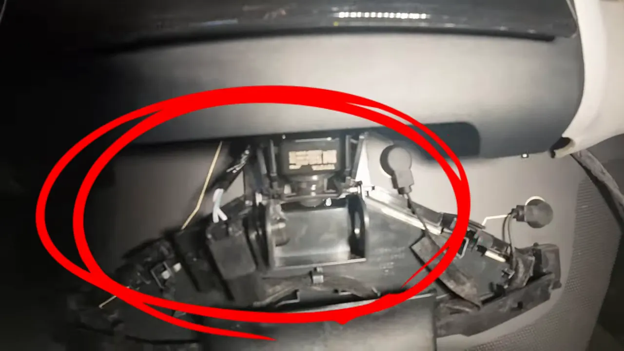 Open rear view mirror housing area showing internal factory camera and mounting space near the windshield