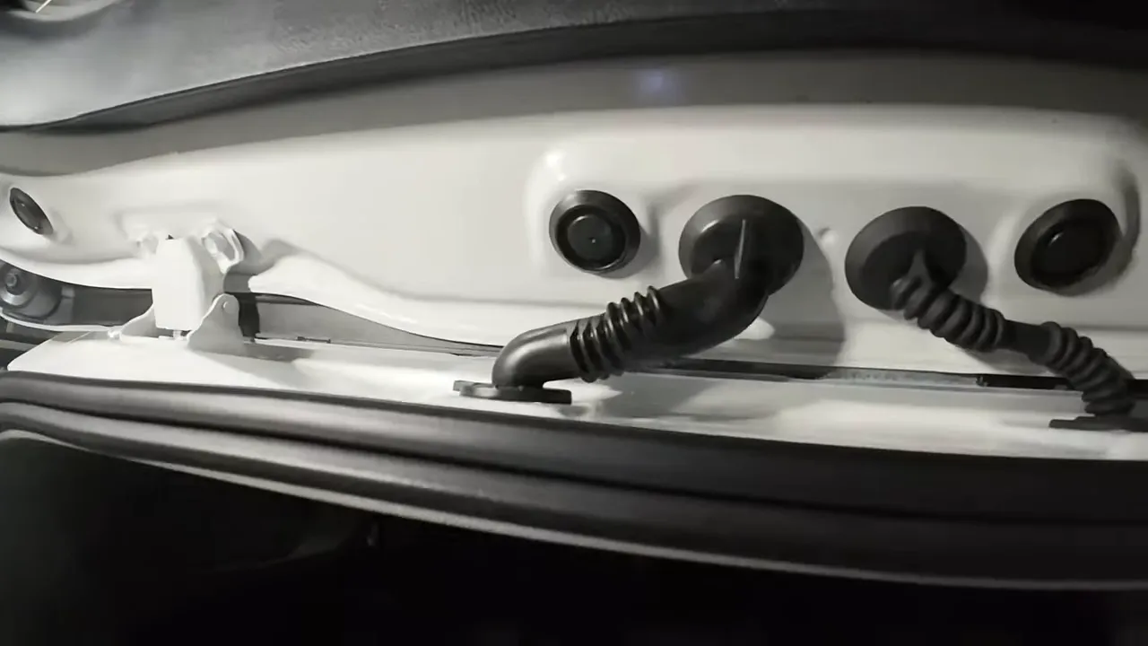 Open rear hatch with wiring routed through factory grommets and secured inside the hatch