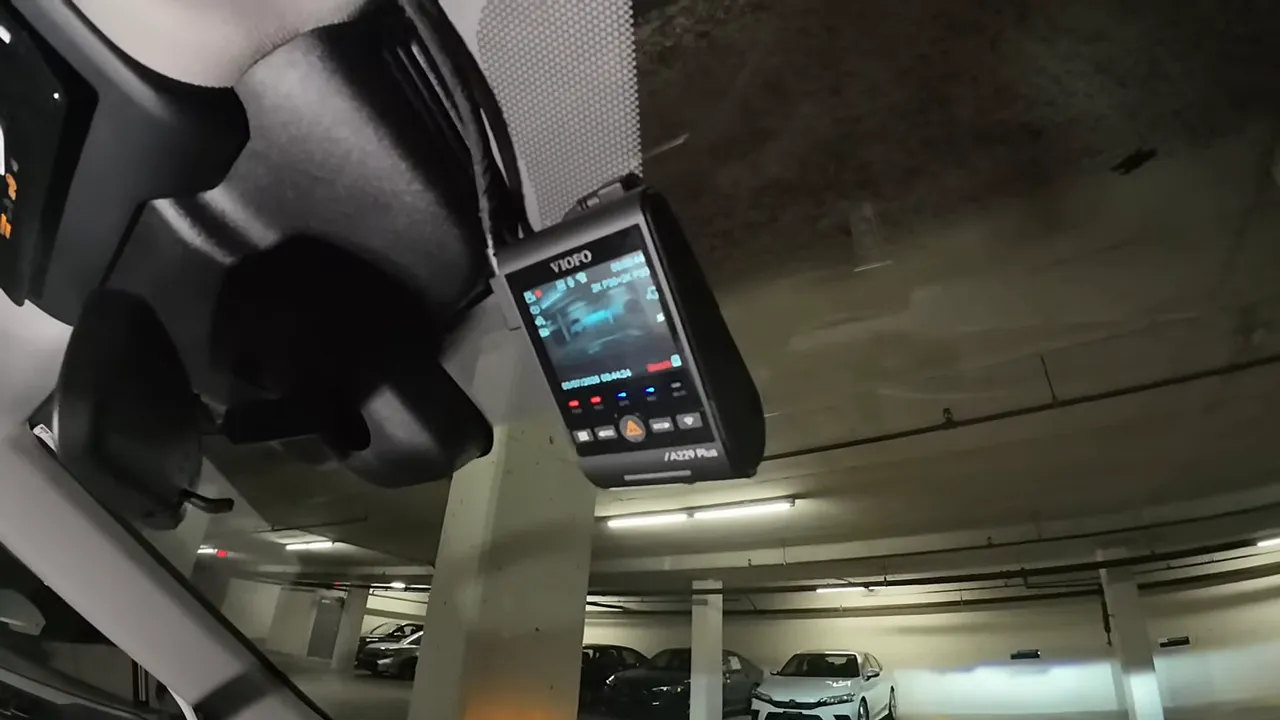 Front dash camera mounted near the rear view mirror with its screen powered on